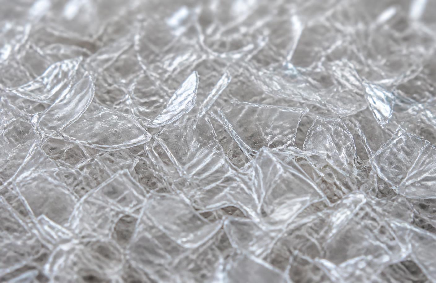 Macro detail of transparent PET flake showing texture and glassy sheen